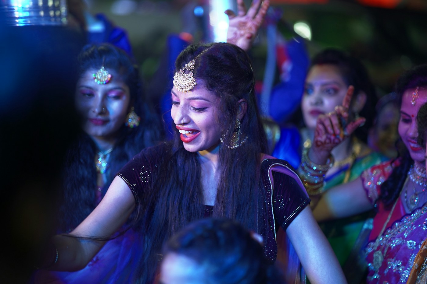 Women dancing in Indian partywear under colourful lights — stock mood photograph